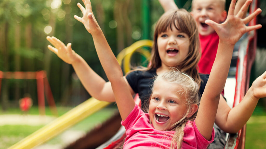 Thriving kids playing on a slide